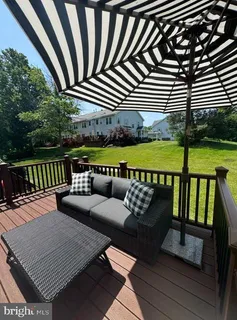 a view of a patio with couches chairs and wooden floor