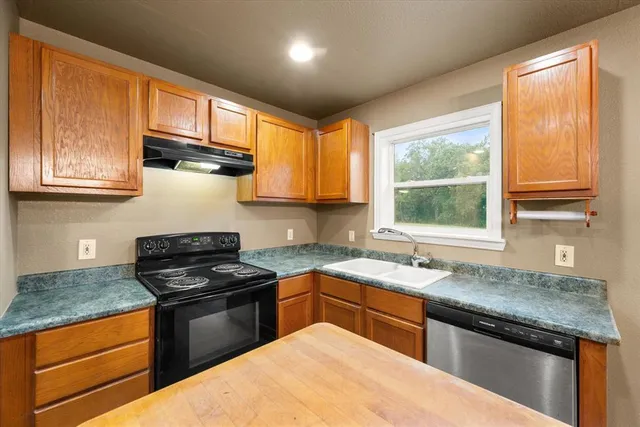 a kitchen with a sink stove top oven and cabinets