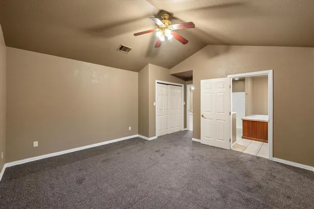 a view of an empty room and chandelier fan