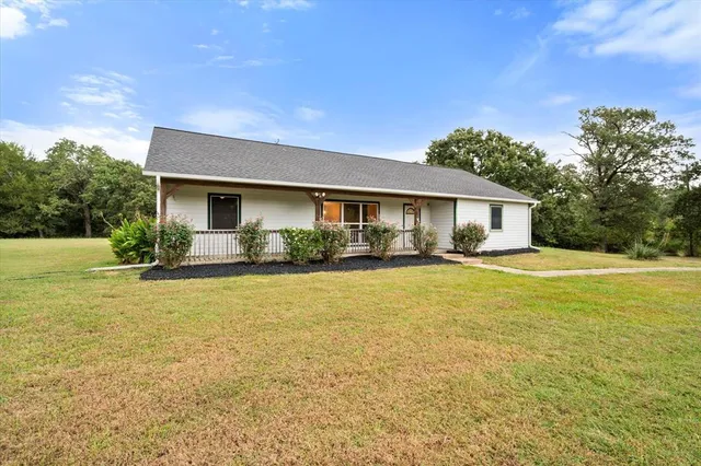 a front view of house with yard and outdoor seating