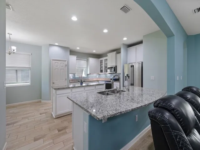 a kitchen with stainless steel appliances granite countertop a sink and a stove
