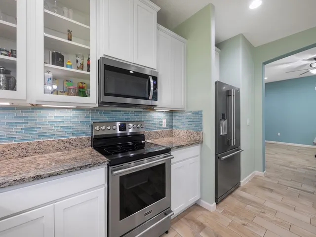 a kitchen with kitchen island granite countertop a sink and a stove top oven