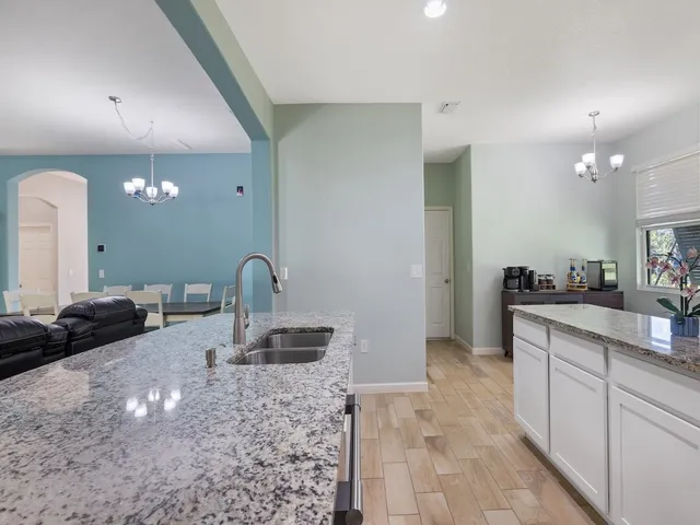 a bathroom with a granite countertop double vanity sink a mirror and a bathtub