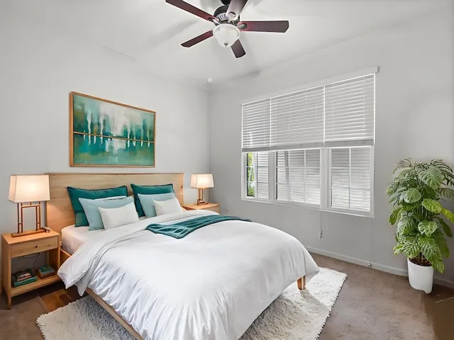 a bathroom with a granite countertop sink a toilet a mirror a bathtub and shower