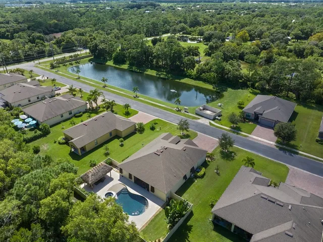 an aerial view of a house with a garden and lake view