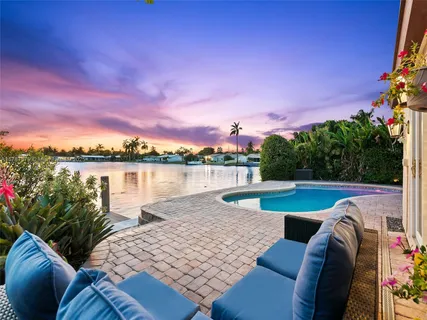 a view of swimming pool with seating space and lake view in back