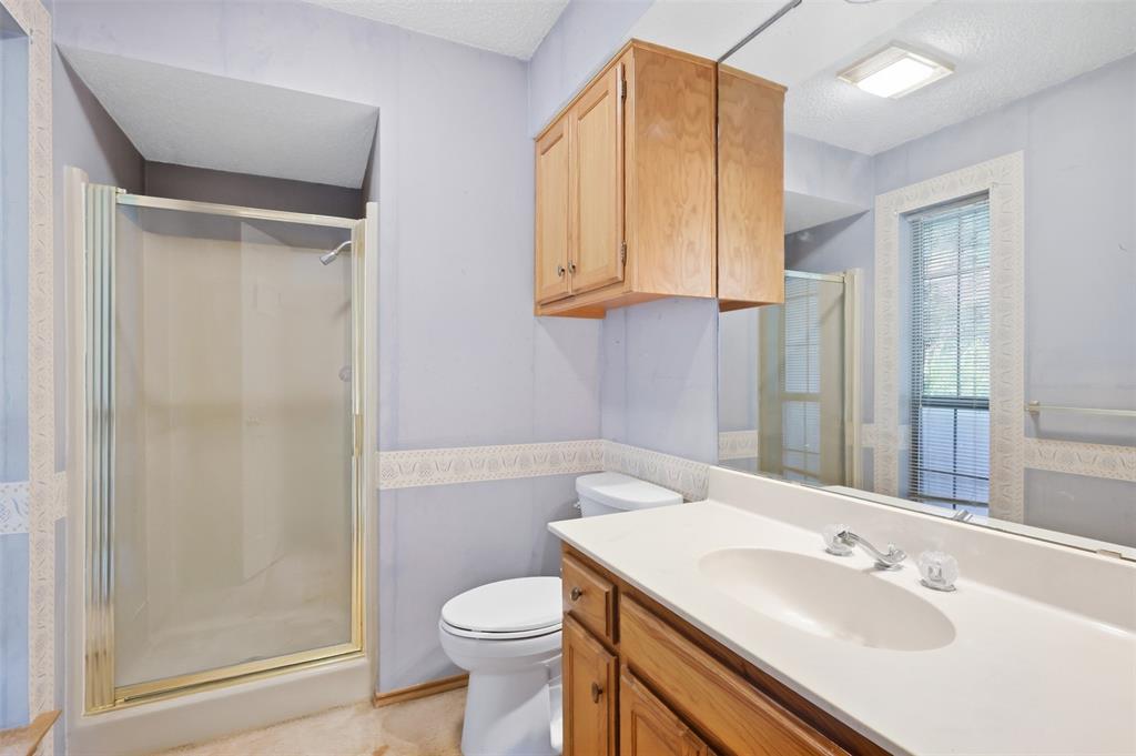 37 Timbergreen Circle Denton, TX 76205 - Photo 11 of 31 Bathroom featuring a built-in shower enclosure, built-in vanity with integrated sink, and an overhead storage cabinet