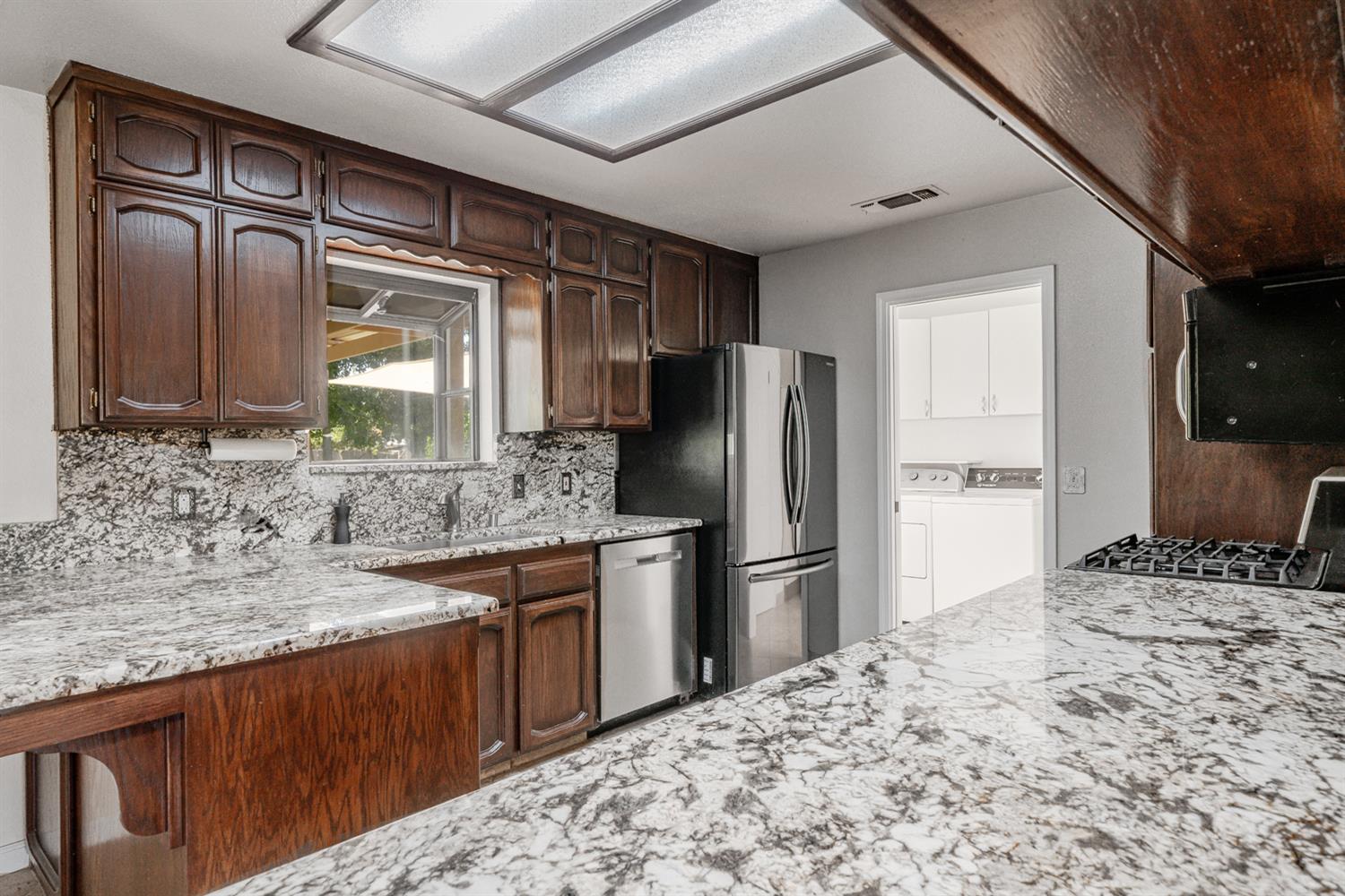 12502 Road 37 1/2 Madera, CA 93636 - Photo 16 of 79 a kitchen with stainless steel appliances kitchen island granite countertop a refrigerator and a sink