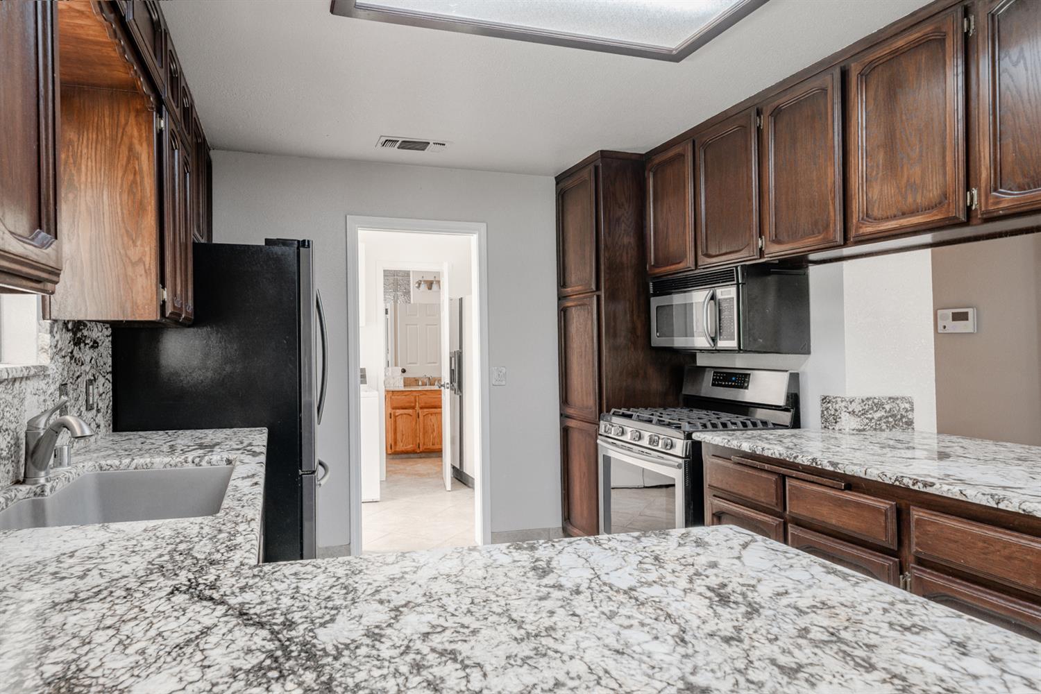 12502 Road 37 1/2 Madera, CA 93636 - Photo 17 of 79 a kitchen with stainless steel appliances granite countertop a refrigerator sink and stove
