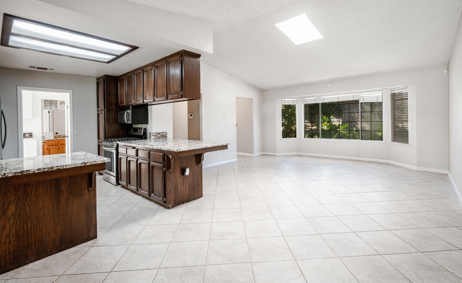12502 Road 37 1/2 Madera, CA 93636 - Photo 18 of 79 a kitchen with stainless steel appliances granite countertop a stove a sink and a microwave