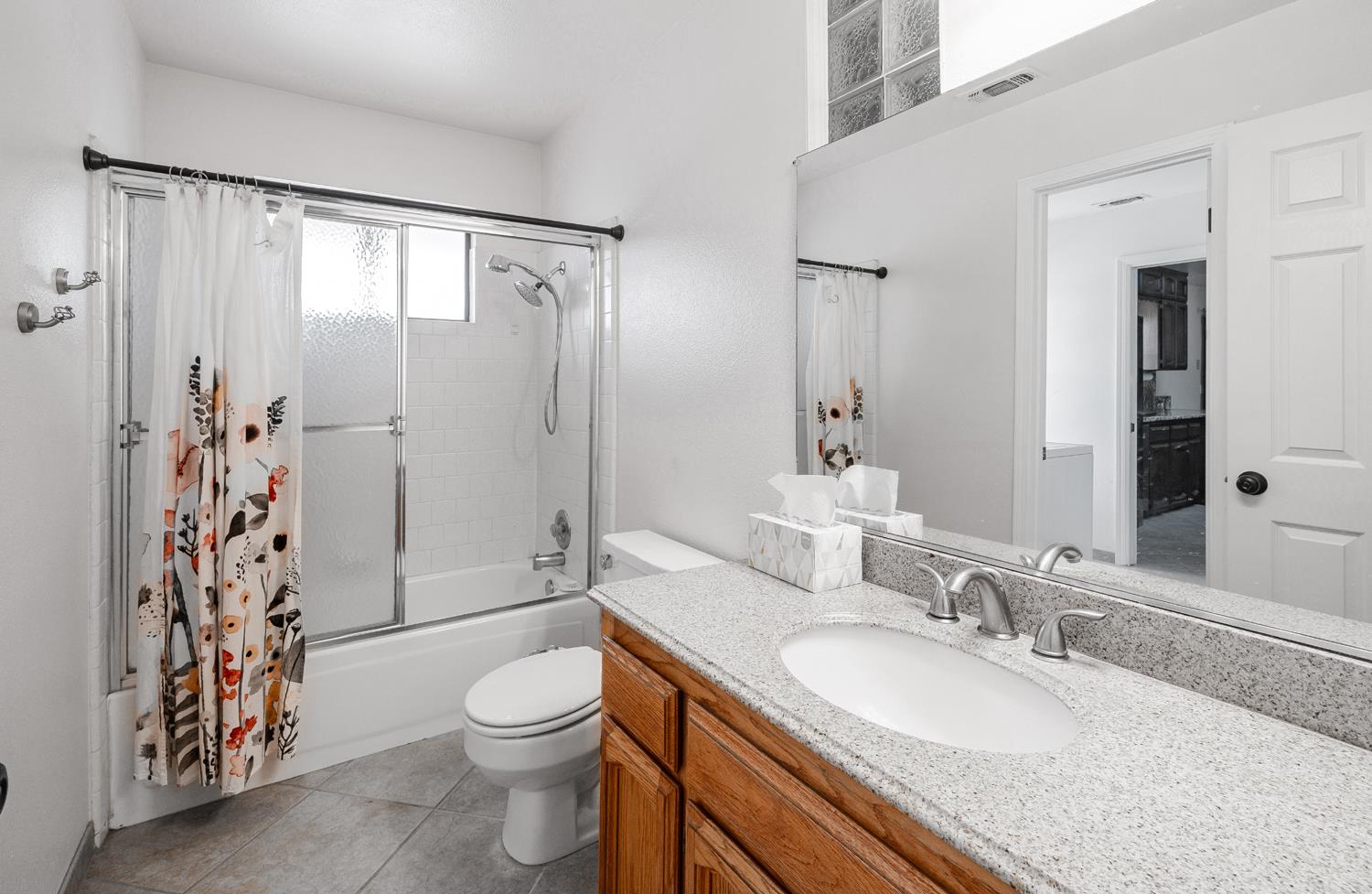 12502 Road 37 1/2 Madera, CA 93636 - Photo 21 of 79 a bathroom with a granite countertop sink toilet a mirror a vanity and shower