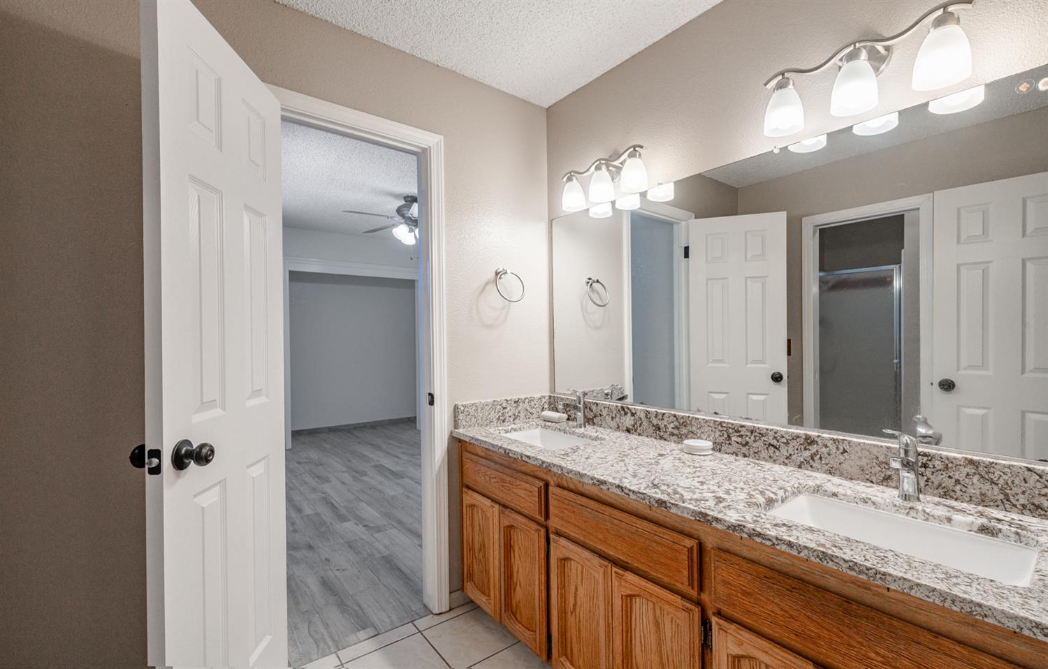 12502 Road 37 1/2 Madera, CA 93636 - Photo 23 of 79 a bathroom with a granite countertop sink and a mirror