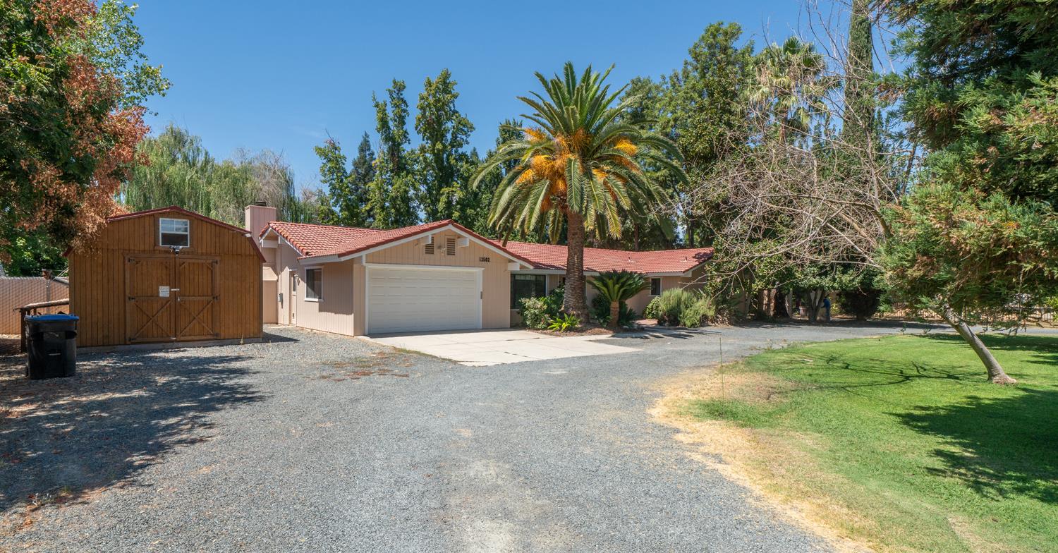12502 Road 37 1/2 Madera, CA 93636 - Photo 36 of 79 a front view of a house with a yard and garage