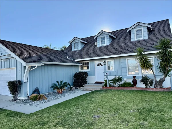 a front view of a house with a garden and plants