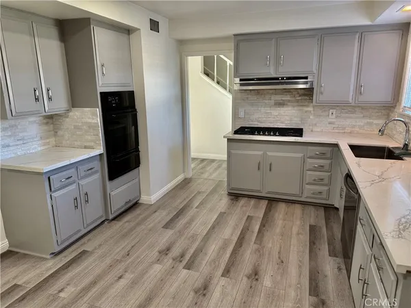 a kitchen with granite countertop a refrigerator stove and oven