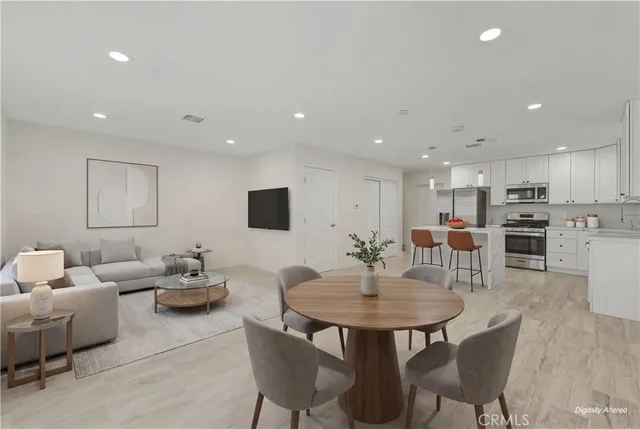 a kitchen with stainless steel appliances kitchen island granite countertop a table and chairs