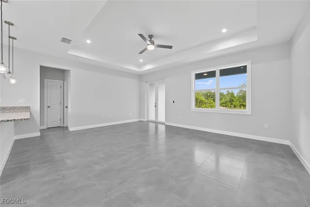 en empty room with windows and ceiling fan