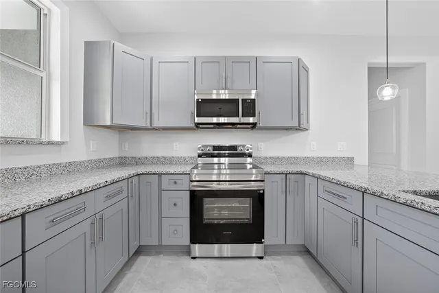 a kitchen with kitchen island a counter top space stainless steel appliances and cabinets