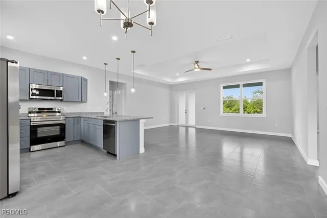 an empty room with windows and ceiling fan