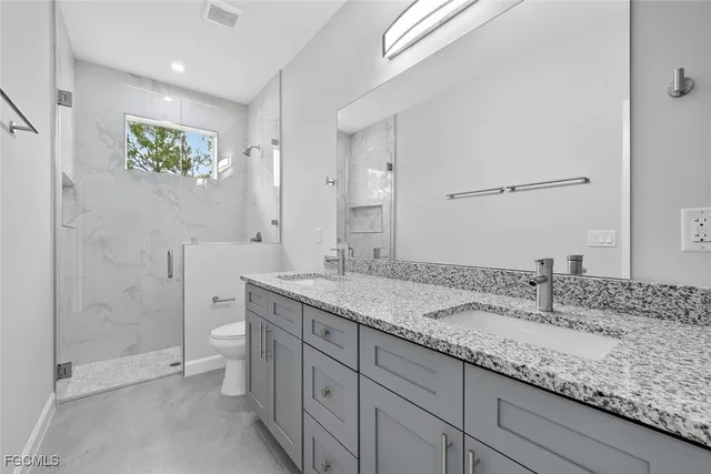 a bathroom with a granite countertop toilet a sink and bathtub