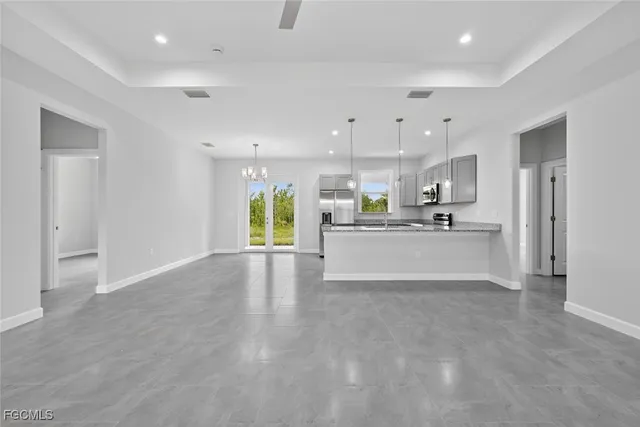 an empty room with windows and ceiling fan