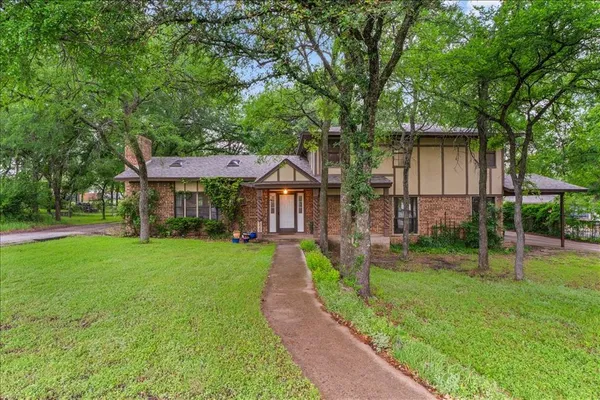 a front view of a house with yard and green space