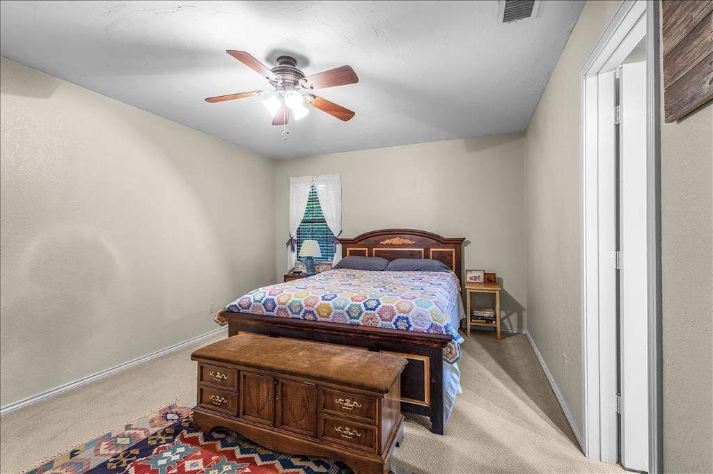 220 Annetta Road Willow Park, TX 76087 - Photo 16 of 40 a bedroom with a bed and a chandelier