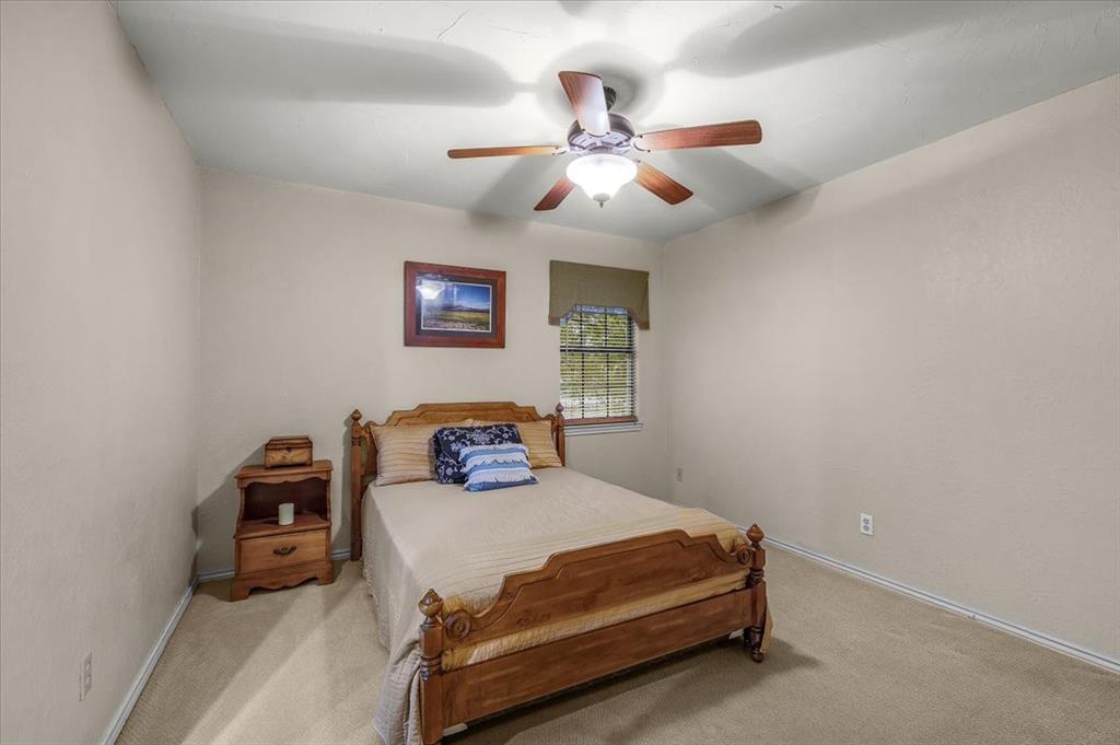 220 Annetta Road Willow Park, TX 76087 - Photo 18 of 40 a bedroom with a bed and a chandelier