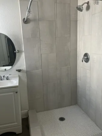 a bathroom with a sink a toilet and shower