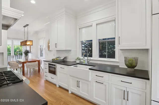 a kitchen with stainless steel appliances granite countertop a stove a sink and white cabinets