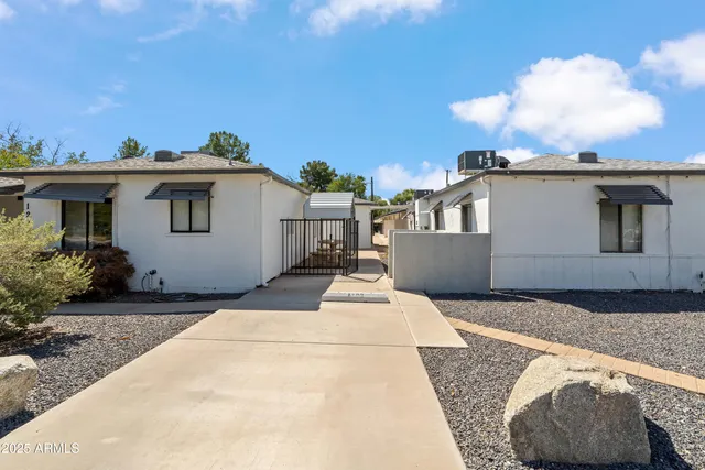 a white house that has tree in front of it