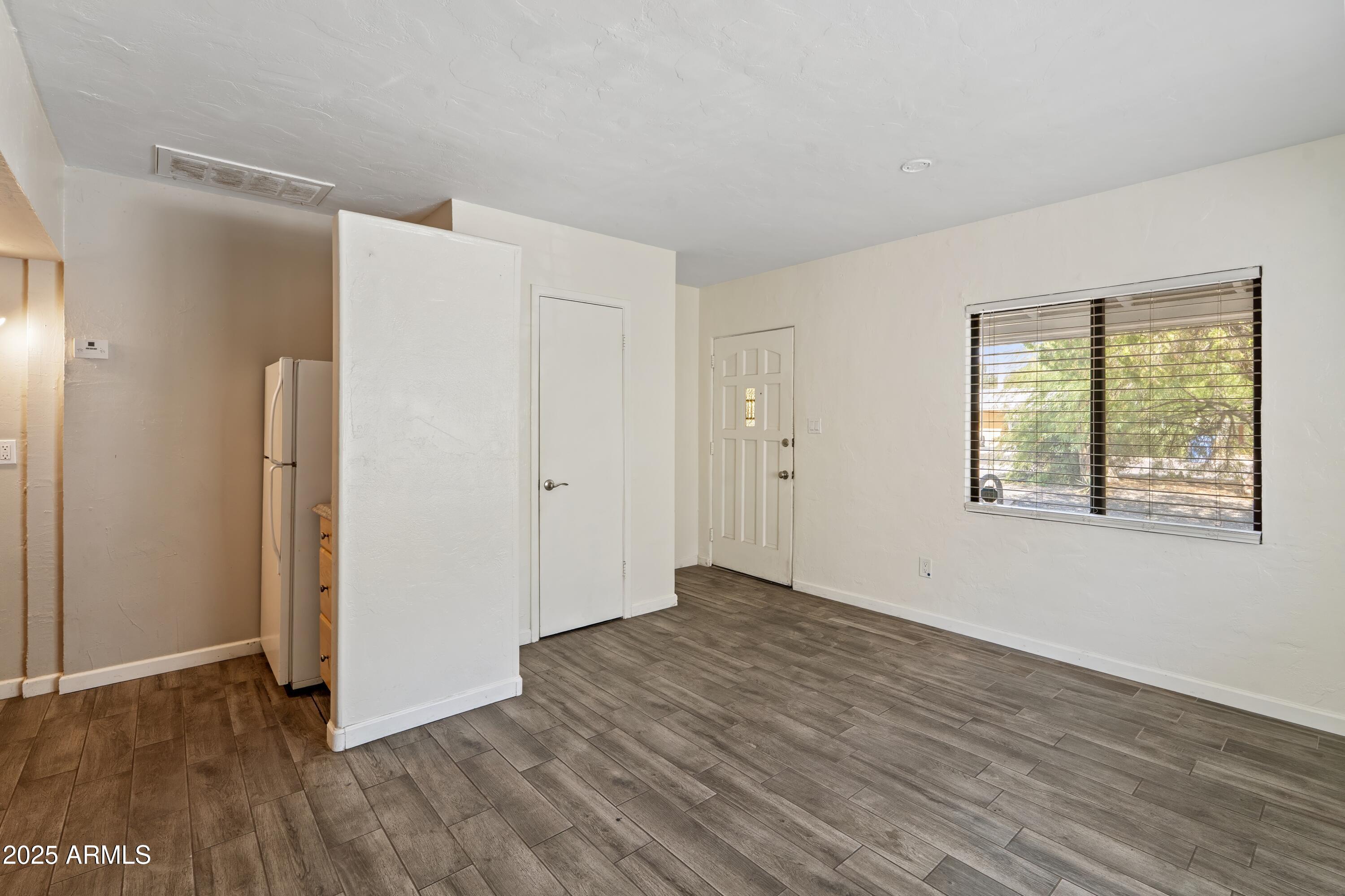 1218 South Farmer Avenue Tempe, AZ 85281 - Photo 20 of 47 a view of an empty room with wooden floor and a window
