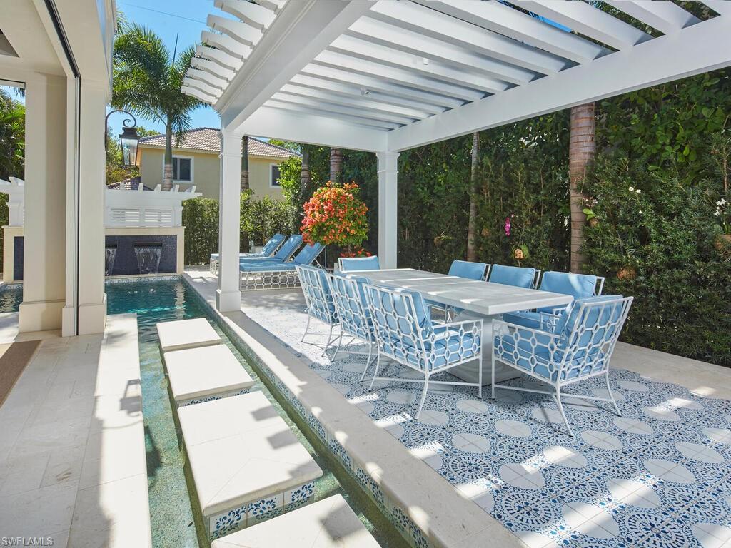 167 4th Street North Naples, FL 34102 - Photo 22 of 33 a view of a patio with a dining table and chairs