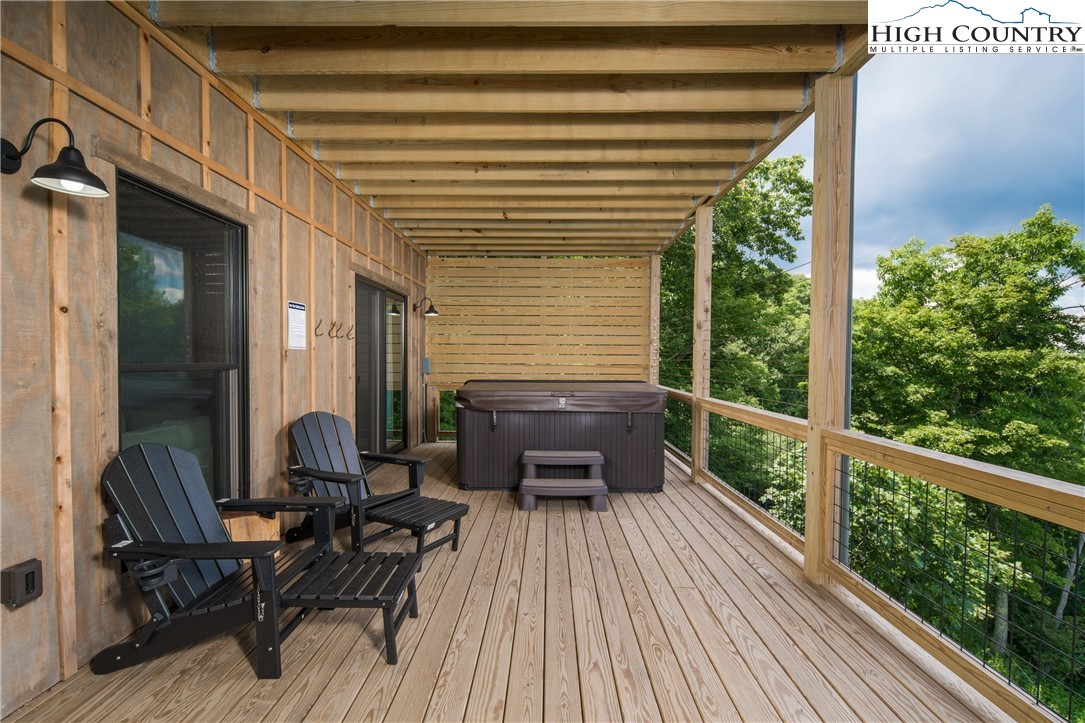 351 Broken Arrow Trail Boone, NC 28607 - Photo 8 of 48 a balcony with furniture and wooden floor