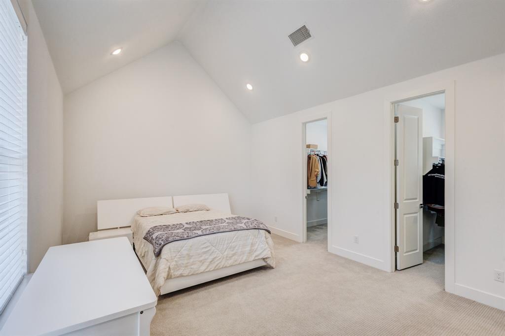 114 Chester Court Dallas, TX 75203 - Photo 19 of 31 a bedroom with a bed and a refrigerator