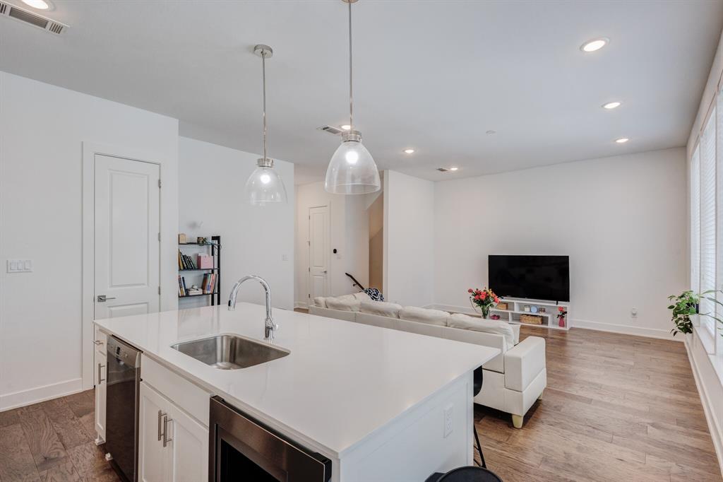 114 Chester Court Dallas, TX 75203 - Photo 3 of 31 a view of kitchen island a sink wooden floor and a living room view