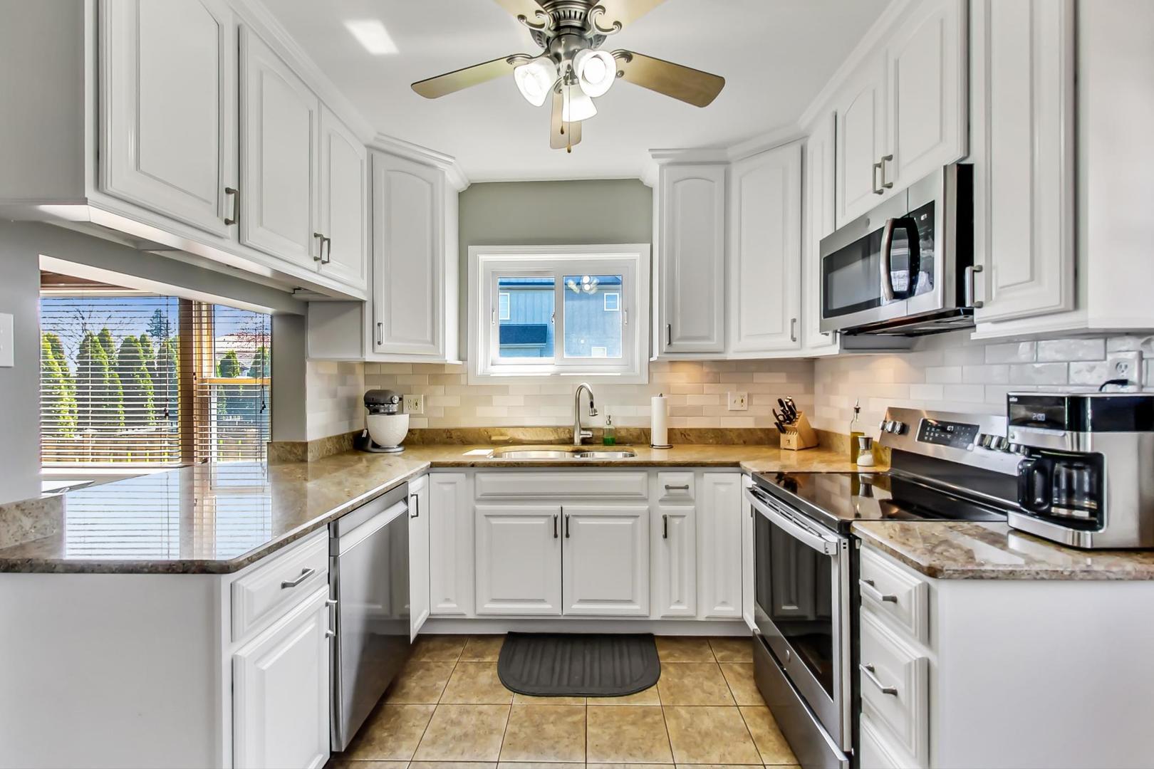 272 North Willow Road Elmhurst, IL 60126 - Photo 9 of 33 a kitchen with stainless steel appliances granite countertop a sink and dishwasher a stove top oven with white cabinets