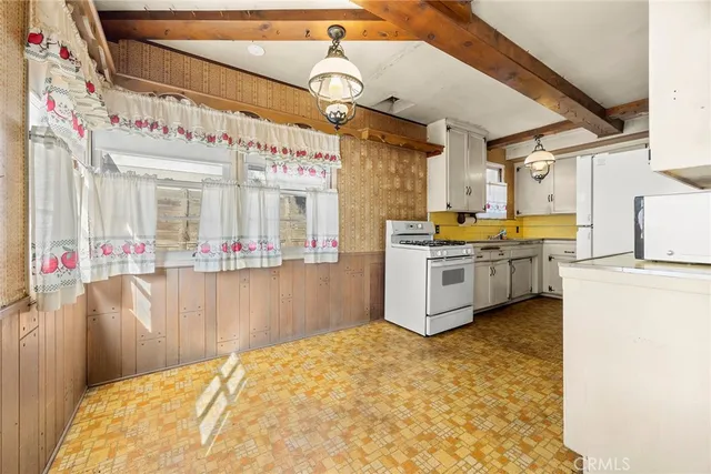 a kitchen with a stove a refrigerator and white cabinets