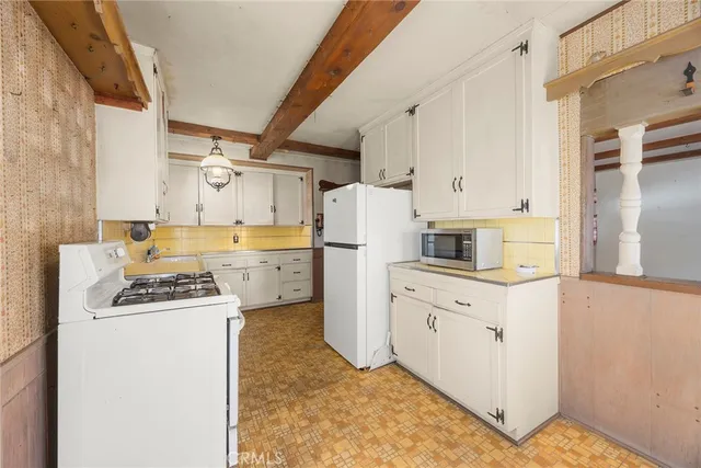 a kitchen with stainless steel appliances granite countertop a sink a stove and a wooden cabinets