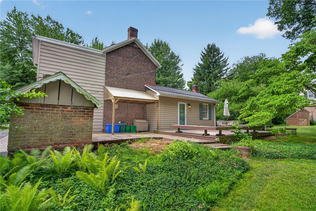 765 East Macada Road Bethlehem, PA 18017 - Photo 7 of 46 Lush landscaping surrounds the expansive wooden deck, perfect for outdoor entertaining.