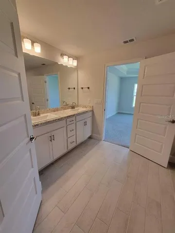 a spacious bathroom with a granite countertop sink a mirror and a vanity