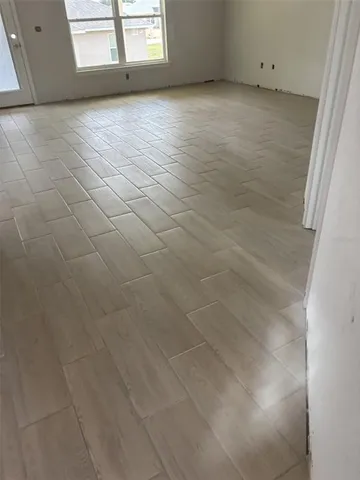 a view of a livingroom with an empty space and a window