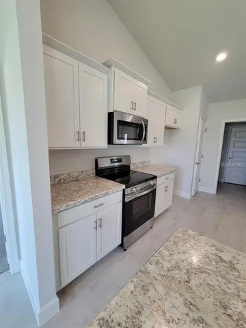 a kitchen with stainless steel appliances a stove a sink and a refrigerator