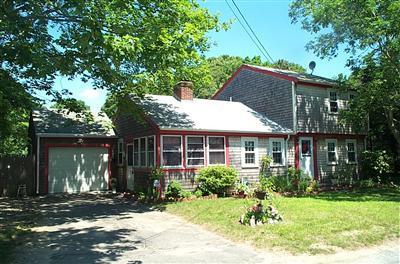 a front view of a house with a yard and potted plants