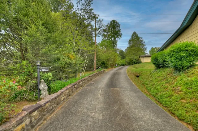 a view of an empty room with window and hardwood floor