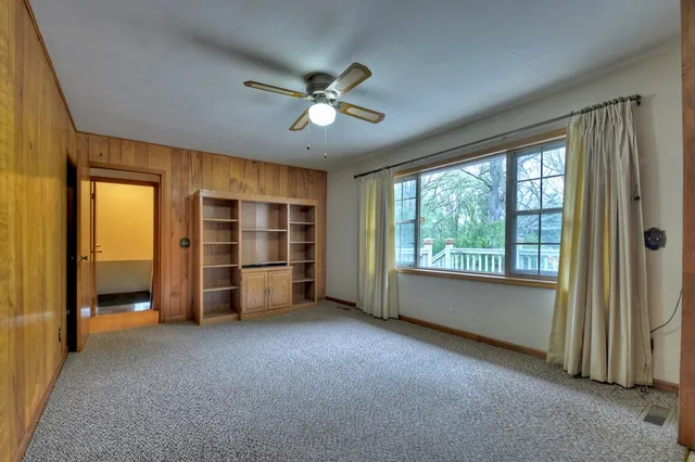 a view of a livingroom with a chandelier wooden floor and windows