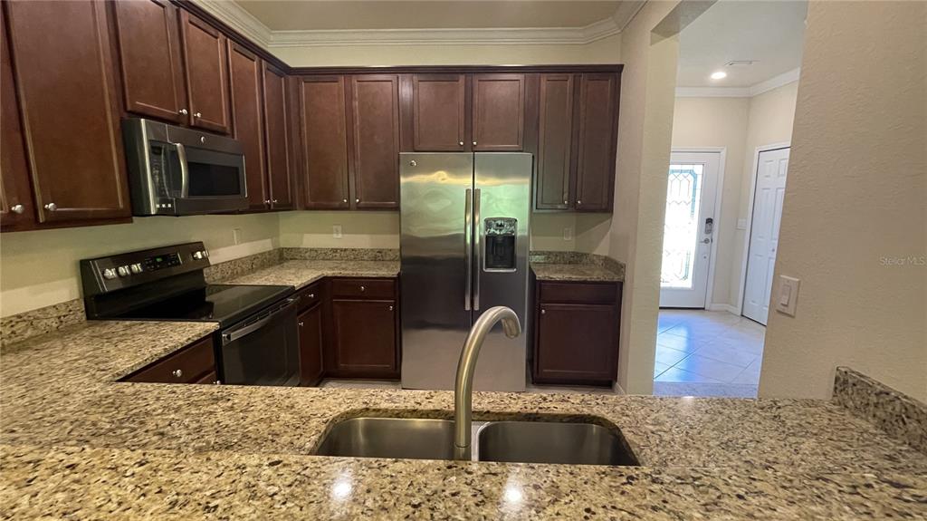 7287 Ketch Place Bradenton, FL 34212 - Photo 6 of 29 a kitchen with stainless steel appliances granite countertop a sink stove and refrigerator