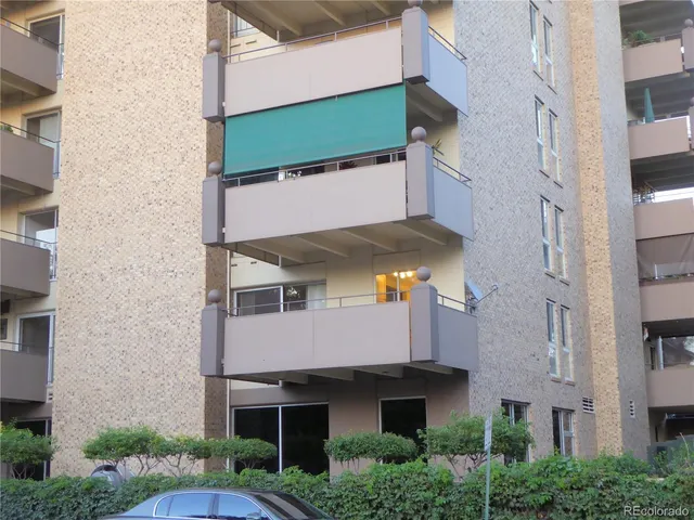a view of building with yard and car parked