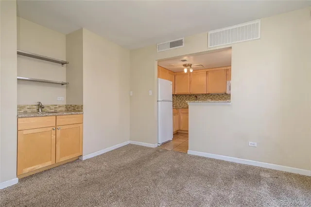 a view of a kitchen with an empty space and wooden floor