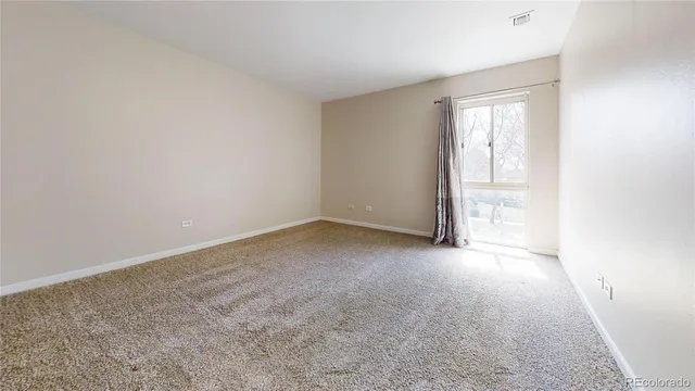 an empty room with fireplace and windows